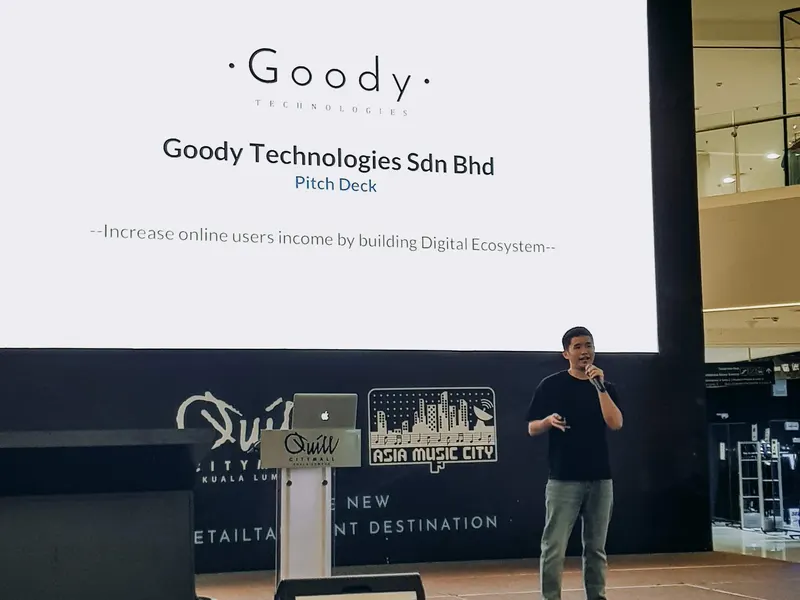 Aaron Lim presenting the Goody Technologies pitch deck on stage at Quill City Mall Kuala Lumpur, 2019